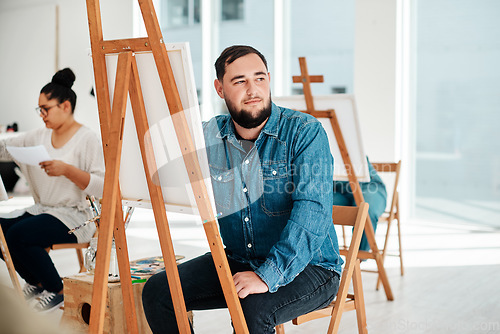 Image of I wonder what colour I should use. Cropped shot of a handsome young artist sitting and looking contemplative during an art class in the studio.