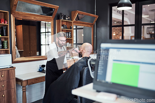 Image of Im the beard expect in this town. Cropped shot of a handsome young barber trimming and lining up a clients beard inside his barbershop.