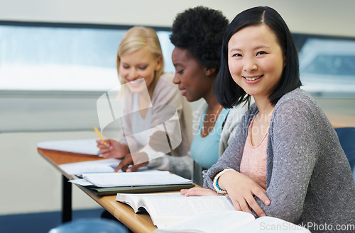 Image of Her education is important to her. A group of students sitting in an exam room.