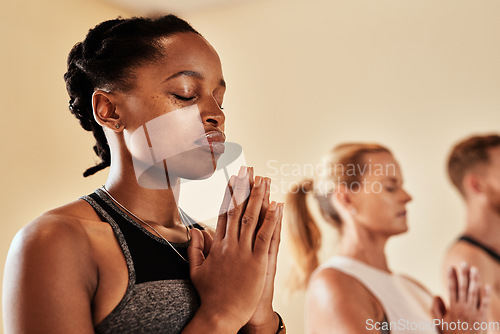 Image of Talk to the universe through meditation. Shot of a group of young men and women meditating in a yoga class.