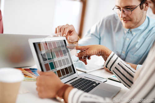 Image of Help me choose a colour. Cropped shot of two young businesspeople sitting together and working with colour schemes on a laptop in the office.