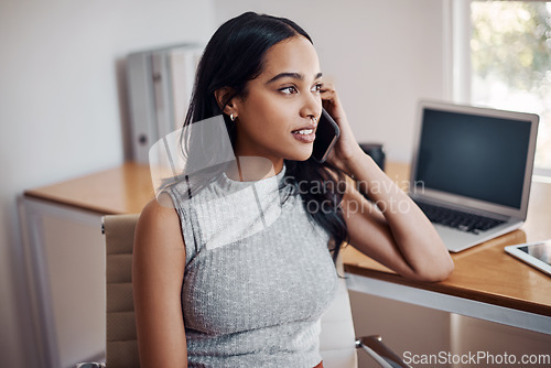 Image of Success is calling her once again. Shot of a young businesswoman talking on a cellphone in an office.