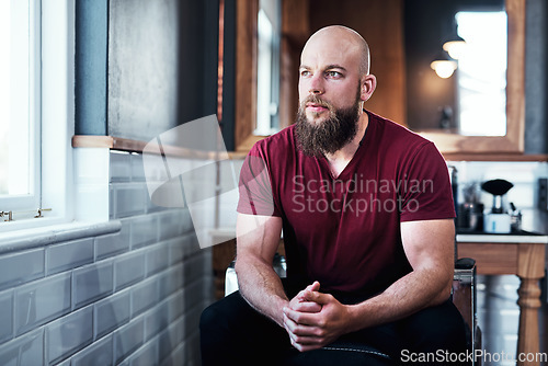 Image of Today is going to be good day for my business. Cropped shot of handsome young barber sitting on a chair inside his barbershop.