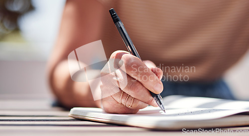 Image of Hand, writing and book with a woman author sitting outdoor in summer for inspiration as a writer. Idea, planning and notebook with a female person using a pen to write in her journal or diary outside