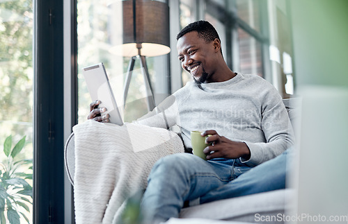 Image of Relax, coffee and tablet with a black man on a sofa, sitting in the living room of his home to browse social media. Smile, technology and internet with a happy male person relaxing alone in a house