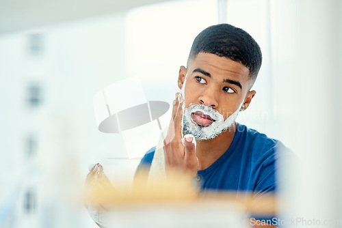 Image of Morning, mirror and shaving with man in bathroom for grooming, hair removal and cleaning. Skincare, razor and self care with face of male person and foam at home for facial, beard and hygiene