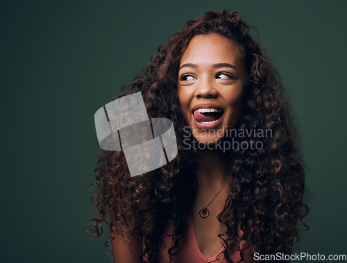 Image of Natural beauty, tongue out and happy gen z girl with hair, curly and curious on green background. Afro, wellness care and female model with fun, emoji and silly face, personality or comic in studio