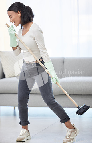 Image of Singing, dance and woman with broom at home for cleaning, hygiene and weekend routine. Music, sing and female person having fun while sweeping a living room floor, happy and enjoying radio in a house