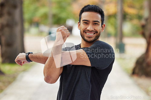 Image of Happy asian man, portrait and stretching arms in fitness getting ready for running, workout or exercise at the park. Male person or runner with smile in warm up arm stretch, training or run in nature