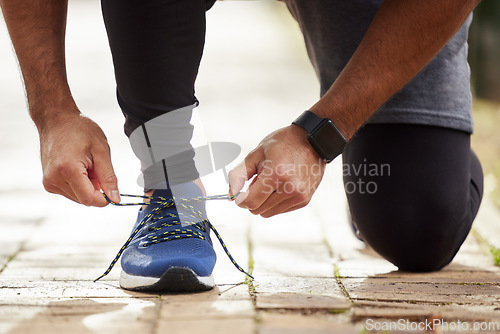 Image of Man, hands and tie shoe in park for running, fitness or cardio workout and exercise in the outdoors. Hand of male person, runner or athlete tying shoes and getting ready for sports training in nature