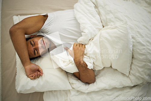 Image of Sleeping problem, headache and man rest in bed with pillow at home with insomnia and fatigue. Morning, male person and house feeling frustrated from pain and sleep issue with blanket in bedroom