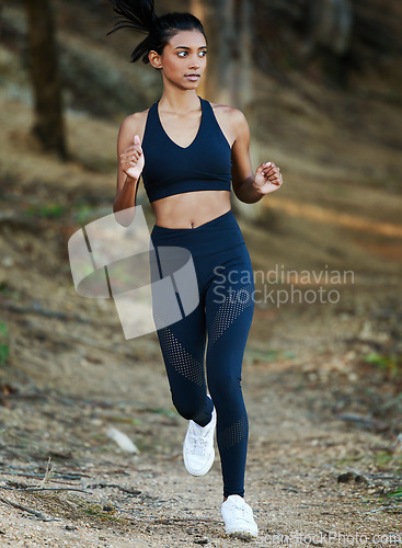 Image of Woman is running in forest, fitness and cardio in nature with exercise and healthy, active lifestyle. Female runner outdoor, training for marathon with speed, energy and workout for health and sport