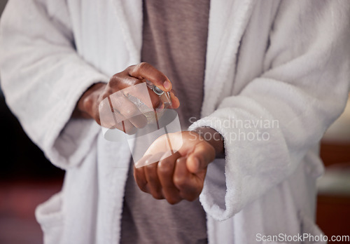 Image of Perfume, man hands and wrist with grooming, cleaning and clean smell at home. Skincare, pajamas and morning routine of a male person with a robe in a house with spray bottle and scent with care