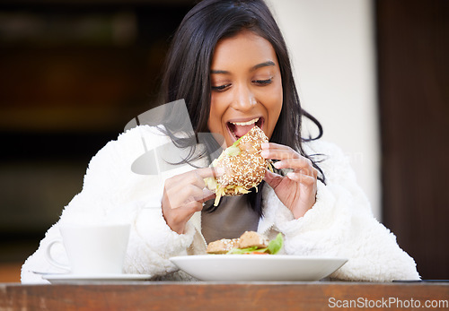 Image of Food, young woman eating and at restaurant with coffee sitting with a happy smile. Breakfast or lunch time, healthy diet or nutrition and happiness with a female person having a meal at a table