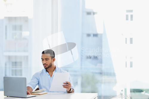 Image of Laptop, documents and business man analyst working on project in office workplace. Computer, paperwork and serious male professional analyze report for finance, planning strategy or typing email.