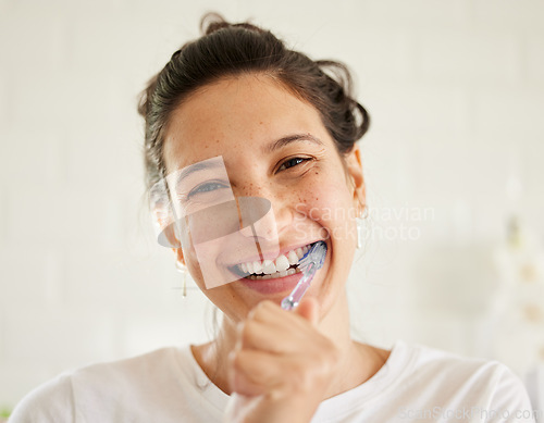 Image of Healthcare, portrait of a woman brush her teeth and smile in her bathroom of her home. Hygiene or self care, health wellness or dental treatment and female person with brushing mouth with toothbrush