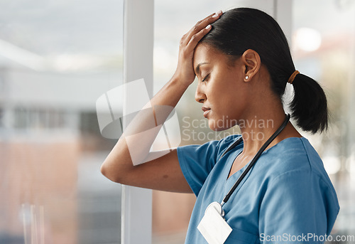 Image of Mental health, doctor with headache and stress standing at window at hospital. Burnout or overworked, anxiety or depression and female nurse or caregiver holding her head for migraine pain at clinic