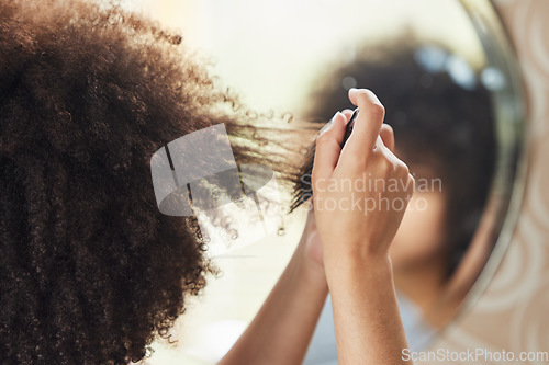 Image of Hair care, woman with afro and comb in mirror for bathroom routine, beauty and morning grooming in home. Haircare, reflection and African model brushing curls from the back, combing curly hairstyle.