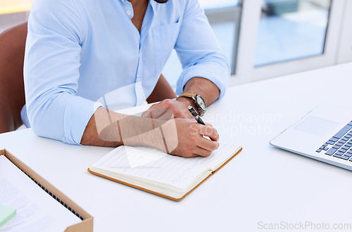 Image of Business man, hands and writing in notebook at desk for planning summary, company report and review with laptop. Closeup, employee and notes for agenda, schedule and planner for information in office