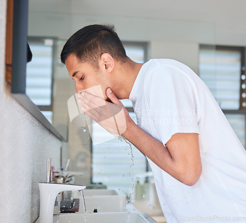 Image of Man washing face, hygiene and beauty in bathroom, skincare and cleaning skin with water for morning routine. Male person at home, grooming and natural cosmetic care with clean facial and hydration