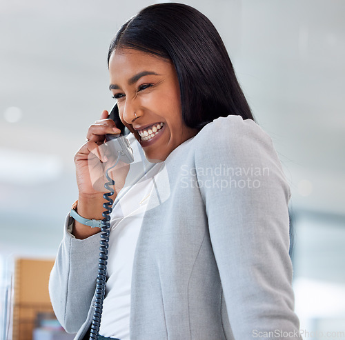 Image of Happy, telephone and woman on a phone call in the office laughing for a comic funny joke. Happiness, smile and professional female employee on a mobile conversation with a landline in the workplace.