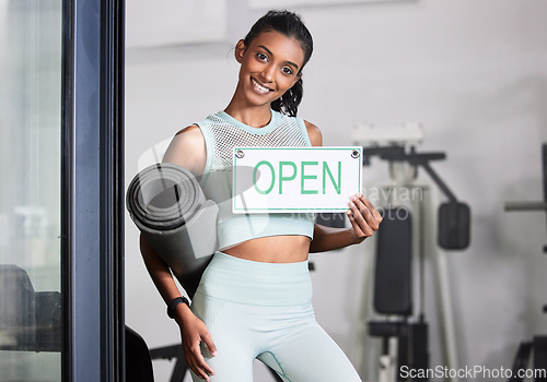 Image of Happy woman, portrait or personal trainer at gym with an open sign for workout exercises or training. Friendly manager, fitness business or healthy girl with a smile holding a board or welcome poster