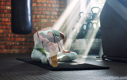 Image of Gym, fitness or flexible woman stretching legs for a workout or body movement for wellness. Warm up, active athlete or healthy girl relaxing her spine in exercise training for flexibility or mobility