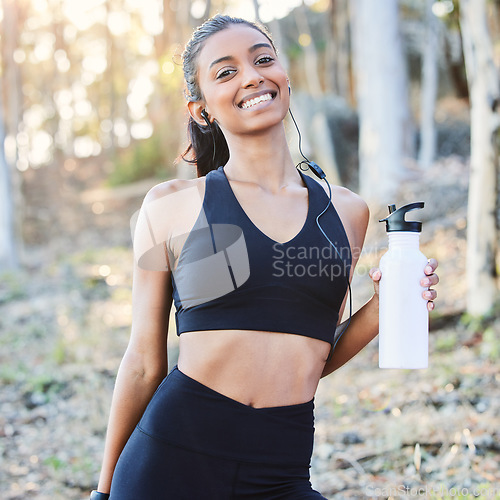 Image of Fitness, nature or portrait of happy woman drinking water in training, running exercise or workout for wellness. Runner, bottle or healthy sports girl on break in park with smile or music headphones