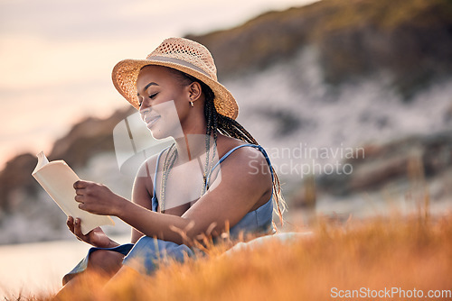 Image of Nature, mountain and woman reading a book while relaxing outdoor on the grass at sunset in summer. Freedom, travel and calm African female person enjoying a novel or fantasy story on hill with peace.