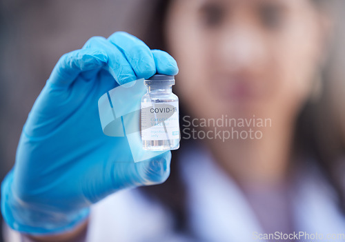 Image of Doctor, covid vaccine and medicine in hand for corona virus in a hospital lab for healthcare and healing. Woman or medical worker with bottle of liquid or pharmaceutical product for safety and health