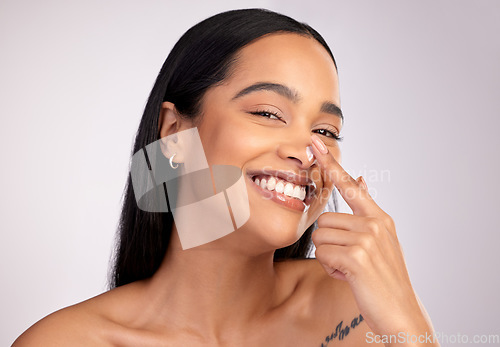 Image of Happy woman, portrait smile and cream on nose for skincare cosmetics against a grey studio background. Face of female person smiling with beauty lotion, SPF or moisturizing creme for facial treatment