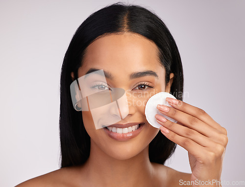 Image of Happy woman, portrait and cotton pad in skincare or makeup removal against a grey studio background. Face of female person wiping product, cosmetics or remove with swab in cleanse or facial treatment