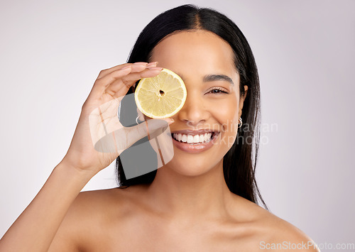 Image of Happy woman, portrait and lemon for natural vitamin C, citrus or healthy nutrition against a grey studio background. Face of female person with fruit in skincare, collagen or antioxidant for diet