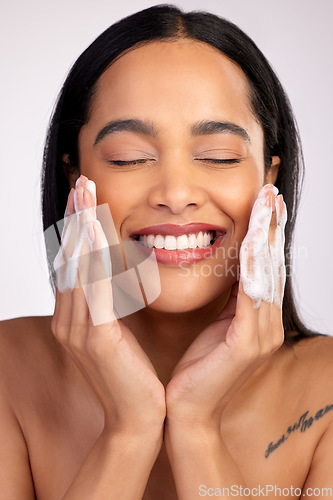 Image of Happy woman, face and washing for skincare hygiene, cleaning or dermatology against a grey studio background. Female person with smile and soap hands for clean facial treatment, self care or love