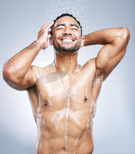 Image of Man in shower with smile, cleaning and soap for hygiene with shampoo, healthy body and studio backdrop. Water, skin and hair care, happy male model washing with foam on background with bathroom spa.