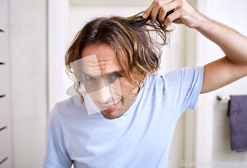 Image of Healthcare, man checking his hair and grooming in bathroom of his home. Mental health or stress, body care or health wellness treatment and male person checking head for haircare at his house