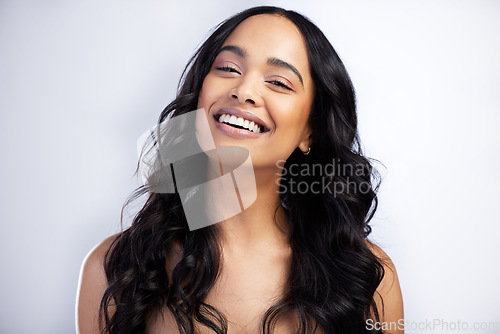 Image of Smile, face and curly hair care of woman in studio isolated on white background for skincare. Portrait, haircare and female model in natural makeup, cosmetics and salon treatment for beauty hairstyle