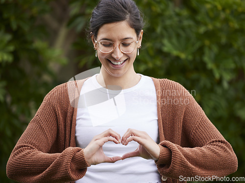 Image of Love, woman make a heart with her hands and smile for or freedom outdoors. Emoji or happiness, affection and female person with hand gesture for positive motivation or support standing outside