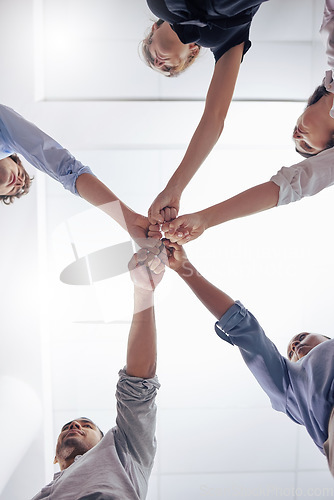 Image of Circle, business people and fist bump for teamwork, below and motivation in workplace, diversity and solidarity. Businessman, women and team building with hands, support and synergy in modern office