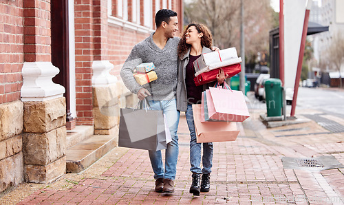 Image of Happy couple, shopping bags and walking in city with gifts for fashion, clothing or buying outdoors. Man and woman in relationship with smile for customer discount, purchase or payment in urban town