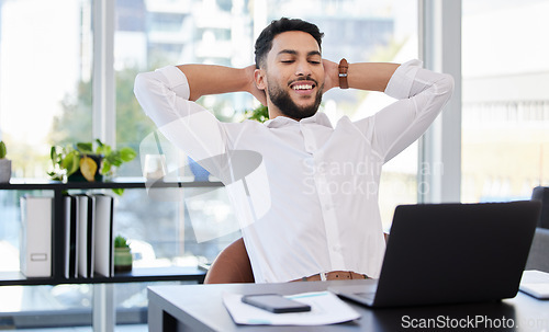 Image of Laptop, relax and happy business man stretching at a desk after deadline, project and review satisfaction in office. Smile, stretch and Mexican male manager relieved with online development or result