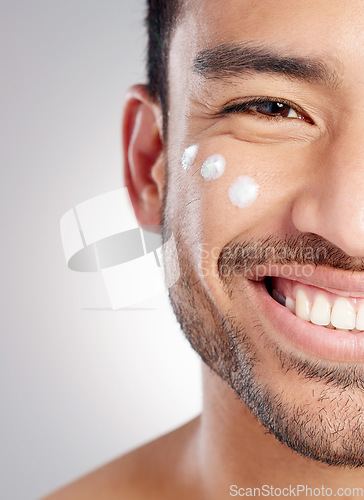 Image of Closeup, portrait and man with skincare, cream and dermatology against grey studio background. Face, male person and model with lotion, creme and grooming routine with a smile, beauty and smooth skin