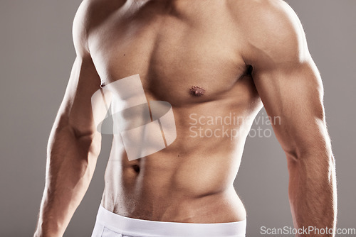 Image of Man stomach, underwear model and muscle with strong chest, abs and body with wellness in studio. Bodybuilder, exercise and male person with gray background and muscles from fitness and workout