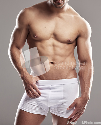 Image of Man body, sexy underwear model and stomach with strong chest, abs and wellness in studio. Bodybuilder, exercise and healthy male person with gray background and muscles from fitness and workout