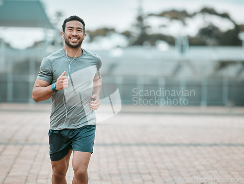 Image of Sports, portrait and male athlete running with earphones for music, radio or podcast for motivation. Fitness, exercise and man runner in outdoor cardio workout routine for race or marathon training.