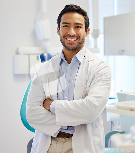 Image of Dentist, portrait and man with arms crossed for healthcare service, dental hospital or insurance in consultation office. Happy asian person or doctor with teeth, oral or hygiene health in clinic