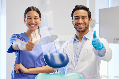 Image of Dentist team, happy portrait and thumbs up for support, thank you or like emoji. Assistant woman and asian man or healthcare staff for dental care, oral health and wellness with a chair at practice