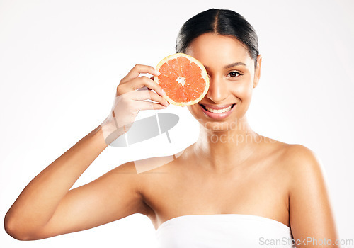 Image of Happy woman, portrait and grapefruit for vitamin C, diet or skincare against a white studio background. Female person smile with organic fruit in healthy nutrition, natural beauty or facial treatment