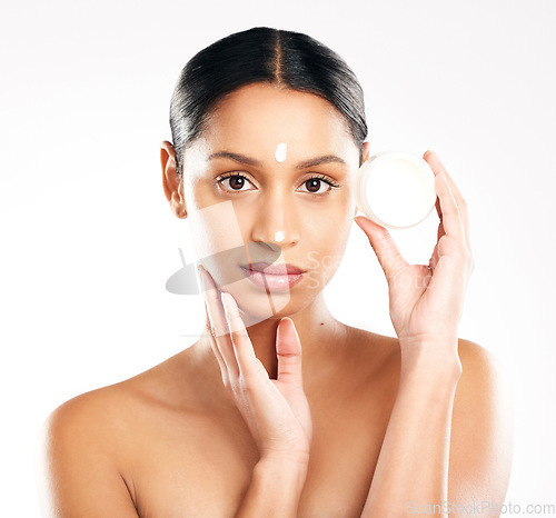 Image of Woman, portrait and cream for skincare, beauty or cosmetics against a white studio background. Face of female person or model with product, lotion or skin creme in dermatology for facial treatment