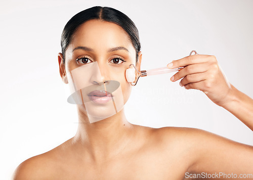 Image of Woman, portrait and face with derma roller in skincare, dermatology or beauty against a white studio background. Female person or model rolling skin in healthy wellness, self care or facial treatment